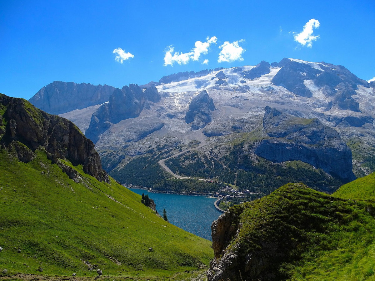 Marmoladas nordsida med glaciären under toppkammen och sjön Lago di Fedaia nedanför