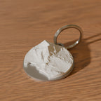 Åre nyckelring i rostfritt stål med 3D-topografi av Åreskutan och Åresjön, på ett ekbord - 3D-rendering av den riktiga modellen